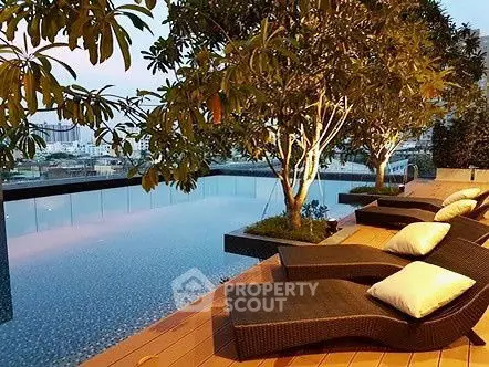 Luxurious rooftop pool with stylish loungers and city view, perfect for relaxation.