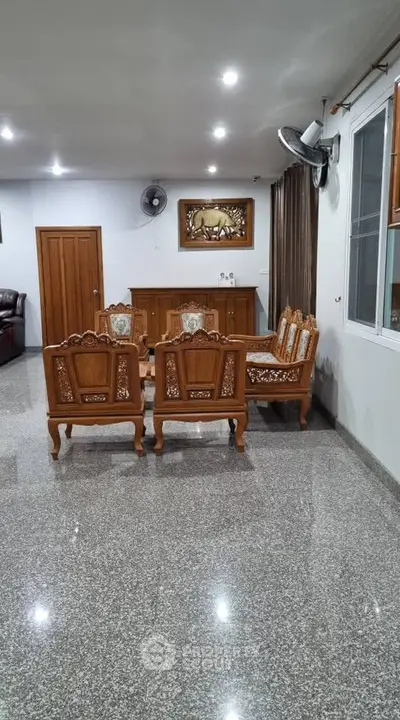 Spacious living room with elegant wooden furniture and polished granite flooring.