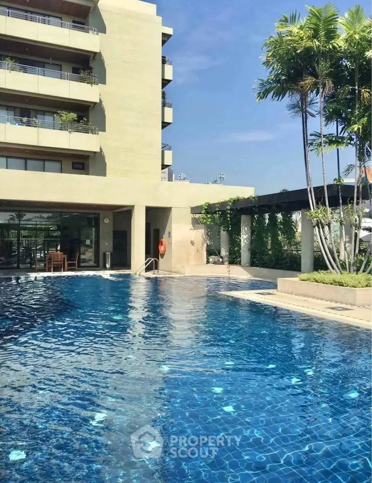Luxurious apartment building with a stunning outdoor pool and lush greenery, perfect for relaxation and leisure.