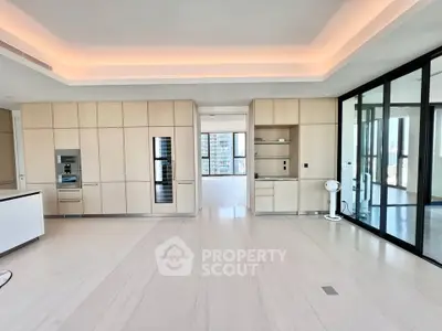 Spacious modern kitchen with sleek cabinetry and large windows offering city views.