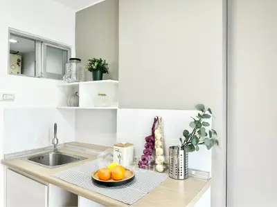 Modern kitchen with sleek design, featuring a compact layout and stylish decor elements.