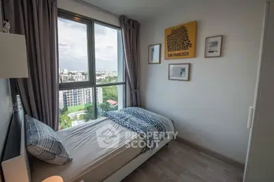 Cozy bedroom with stunning city view and modern decor in high-rise apartment.