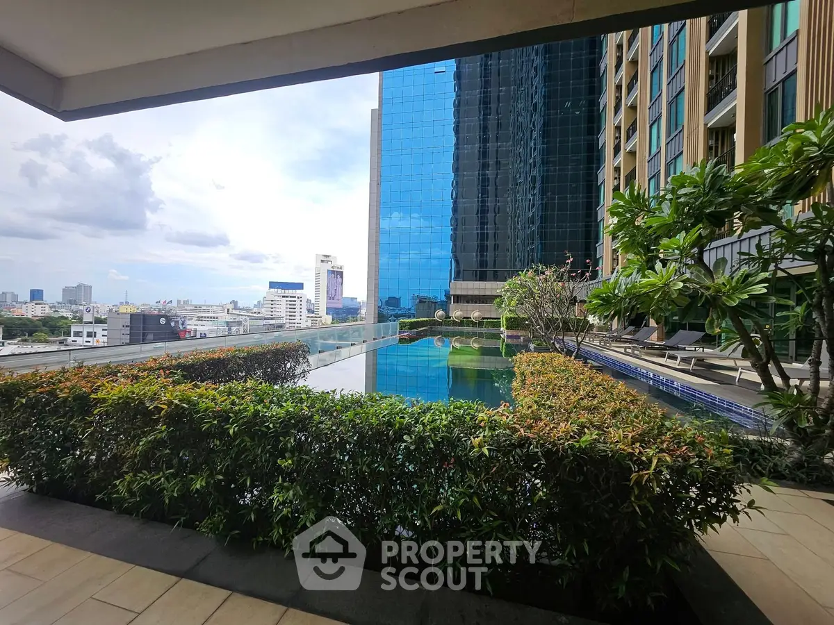 Luxurious rooftop pool with stunning city view and lush greenery in modern high-rise building.
