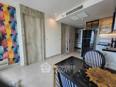 Stylish modern apartment interior with colorful accent wall and sleek kitchen area.