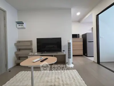 Modern living room with sleek TV setup and open kitchen view