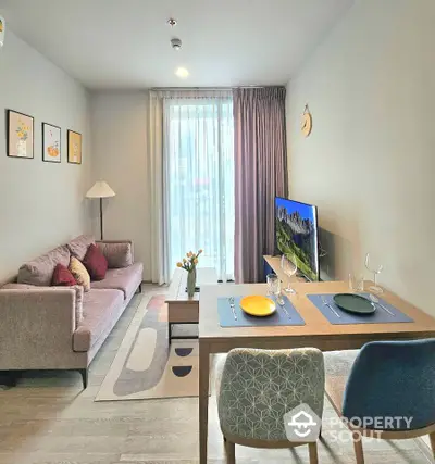 Modern living room with stylish decor and dining area, featuring a cozy sofa and large window.