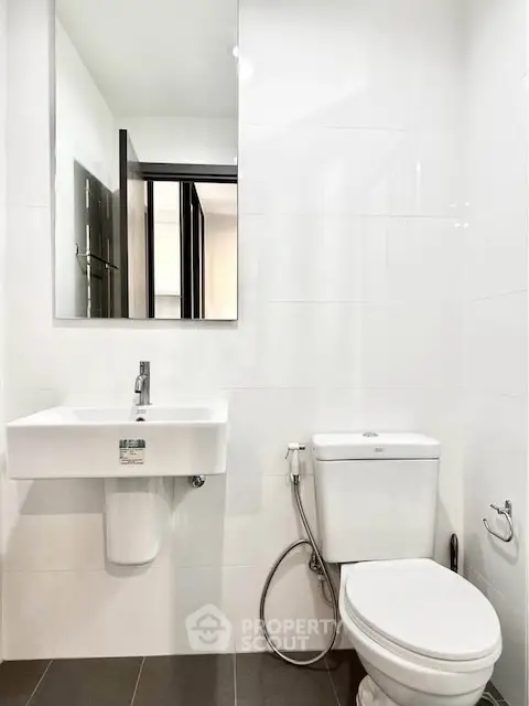 Modern bathroom with sleek white fixtures and minimalist design.