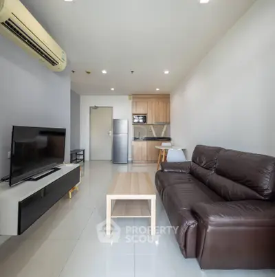 Modern living room with sleek furniture and open kitchen layout in a stylish apartment.