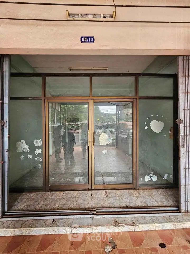 Commercial property entrance with glass doors and tiled flooring, ideal for retail or office space.