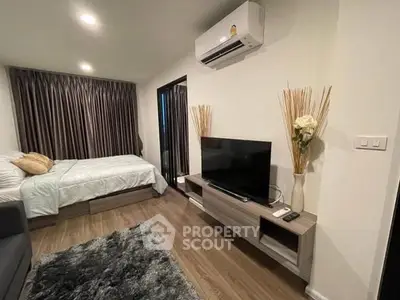 Modern bedroom with cozy decor and sleek furnishings, featuring a TV and air conditioning.