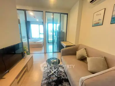 Modern living room with cozy sofa and view into stylish bedroom, perfect for urban living.