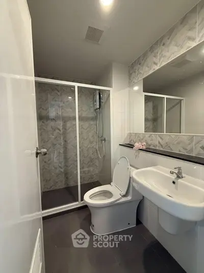 Modern bathroom with sleek shower and elegant fixtures in contemporary apartment.