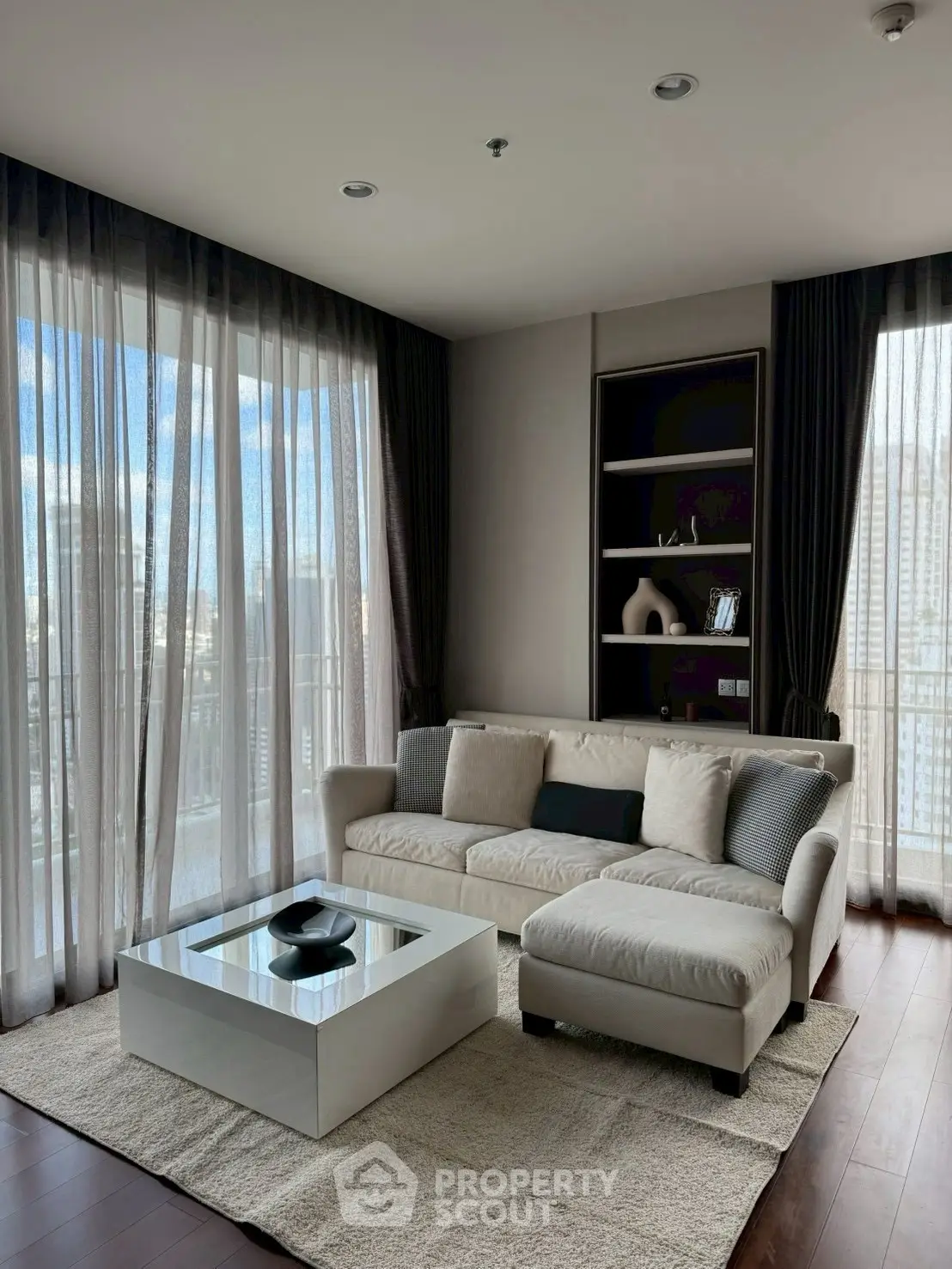 Elegant living room with city view, modern sofa, and stylish decor.