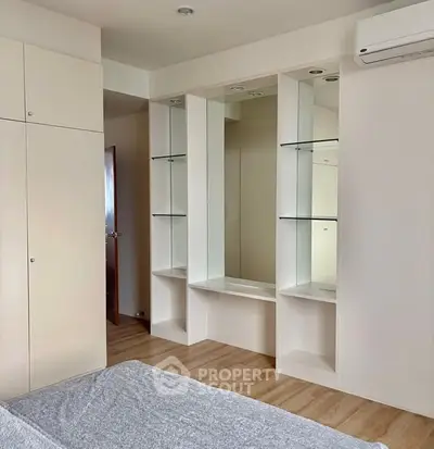 Modern bedroom with built-in storage and air conditioning, featuring sleek design and ample natural light.