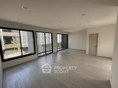 Spacious modern living room with large windows and sleek flooring