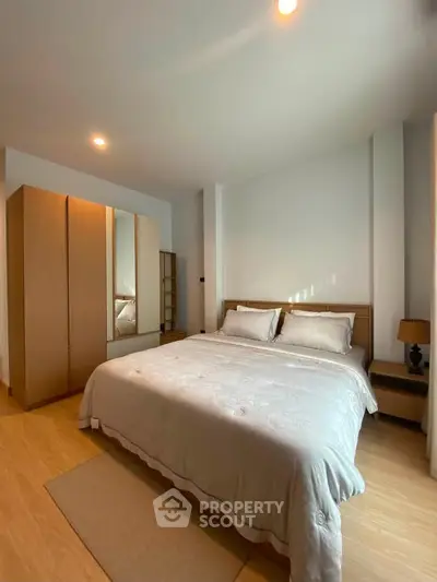 Spacious bedroom with cozy lighting and modern wooden furniture.