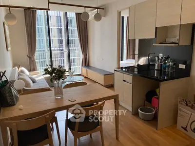 Modern open-layout apartment with stylish kitchen and cozy living area, featuring floor-to-ceiling windows.
