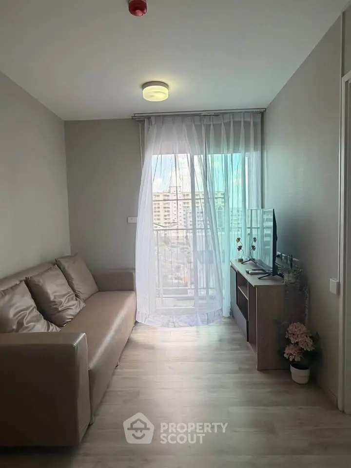 Cozy living room with modern decor and city view through sheer curtains.