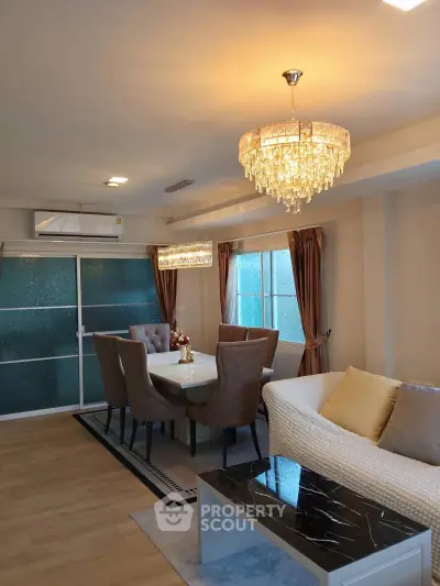 Elegant living room with modern chandelier and stylish dining area
