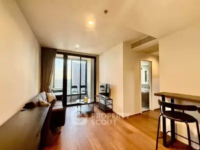 Modern living room with wooden flooring and balcony view in a high-rise apartment.