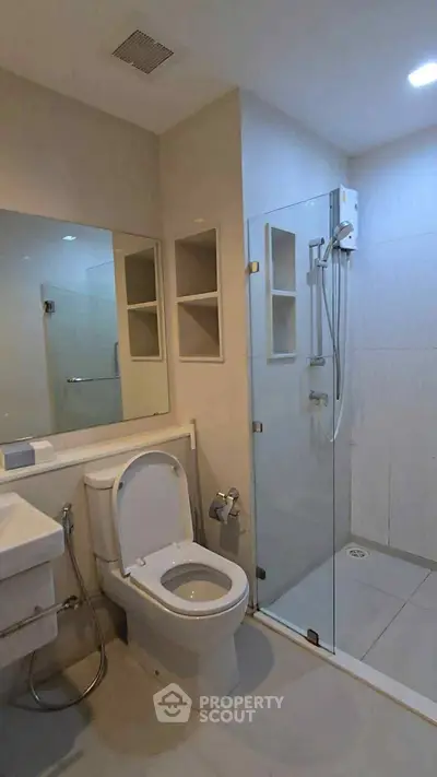 Modern bathroom with glass shower enclosure and sleek fixtures