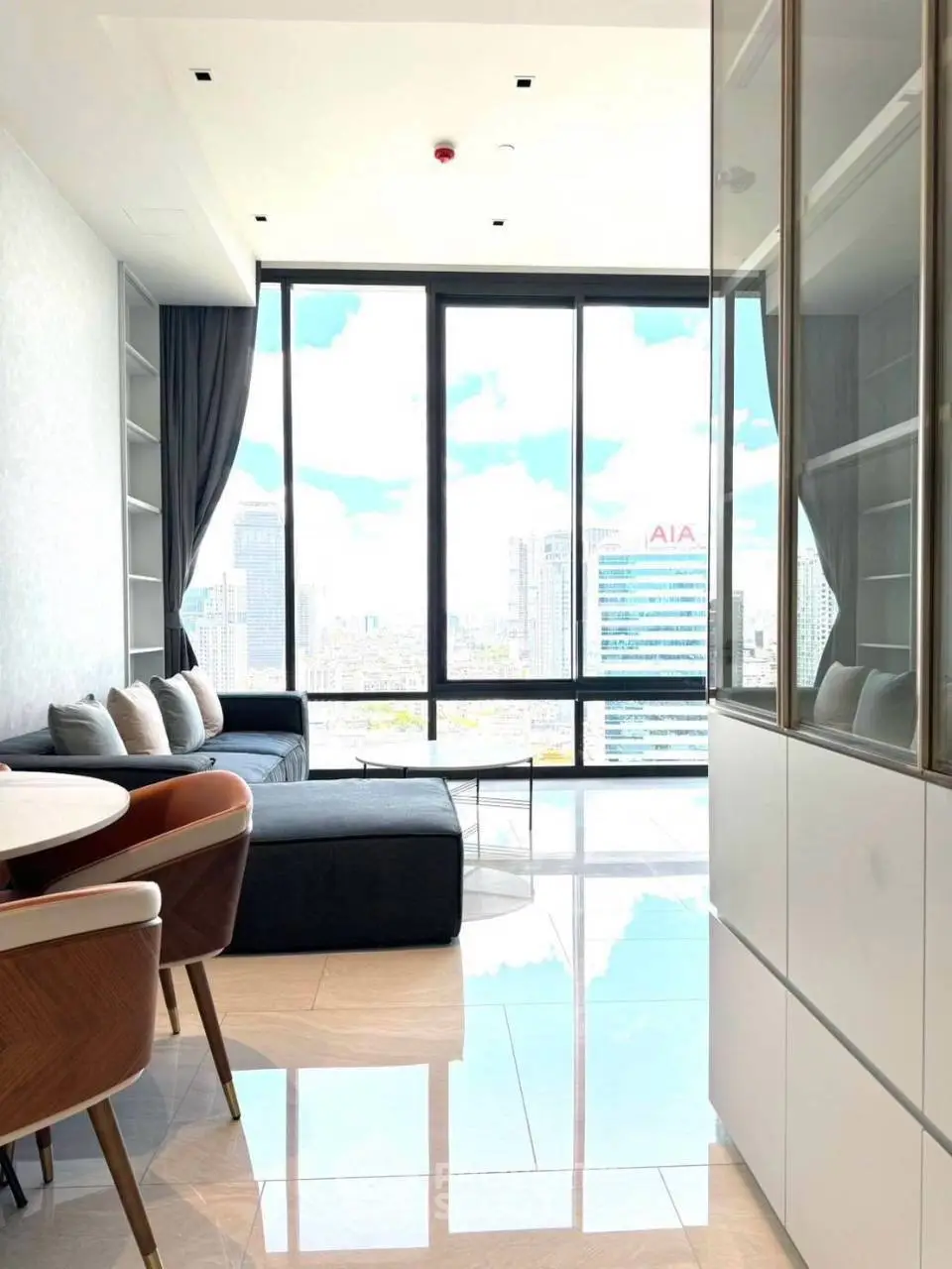 Modern living room with floor-to-ceiling windows offering stunning city views.