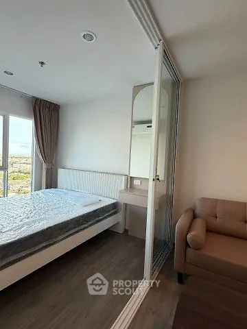 Modern bedroom with large window and cozy seating area