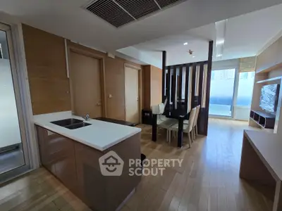 Modern open-plan living room with dining area and sleek kitchen in a stylish apartment.