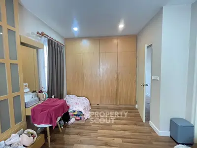 Cozy bedroom with wooden flooring and ample storage space