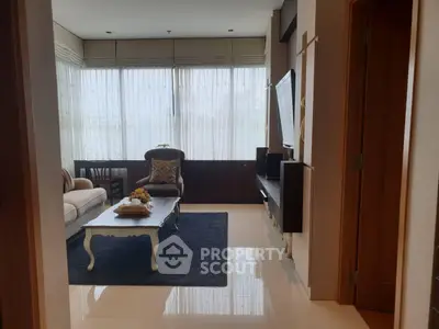 Elegant living room with large windows and stylish furniture, perfect for relaxation and entertainment.