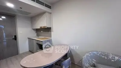 Modern compact kitchen with sleek cabinetry and dining area in a stylish apartment.