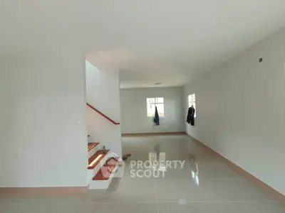 Spacious modern living room with glossy tiled floors and staircase
