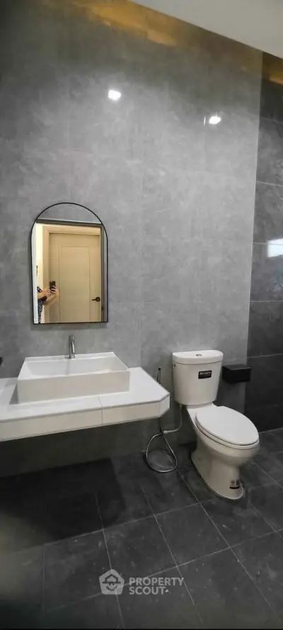 Modern bathroom with sleek design featuring a wall-mounted sink and toilet.