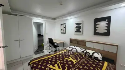 Modern bedroom with stylish decor and workspace, featuring sleek furniture and contemporary art.