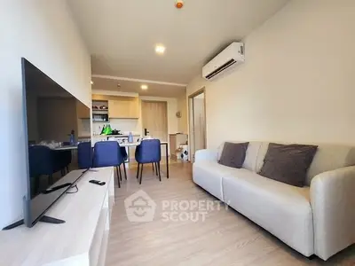 Modern living room with sleek furniture and open kitchen layout in a stylish apartment.