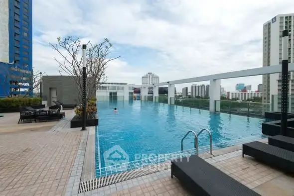 Luxurious rooftop pool with stunning city views in modern high-rise building.