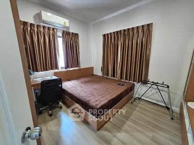 Cozy bedroom with polished wooden flooring, comfortable large bed, and elegant brown curtains, perfect for restful nights in a modern home.