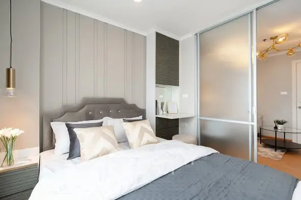 Modern bedroom with stylish decor and sliding glass doors in a contemporary apartment.