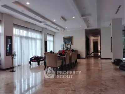 Luxurious dining area with elegant furniture and marble flooring in a spacious open layout.