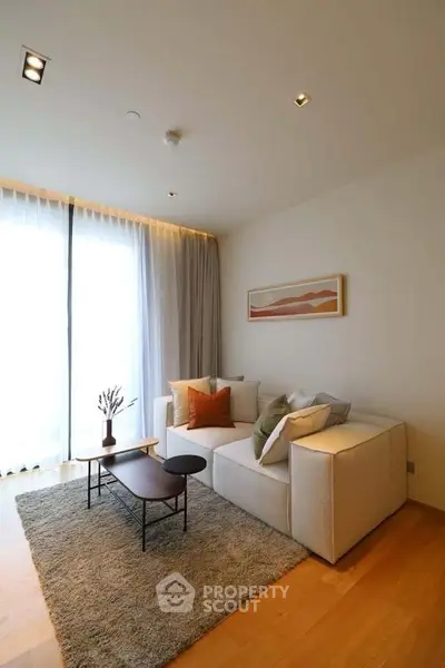 Modern living room with cozy sofa, stylish decor, and large window for natural light.