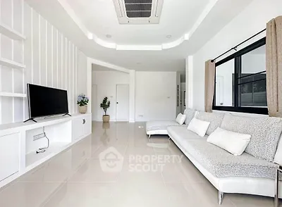 Spacious modern living room with sleek furniture and large window, perfect for relaxation and entertainment.
