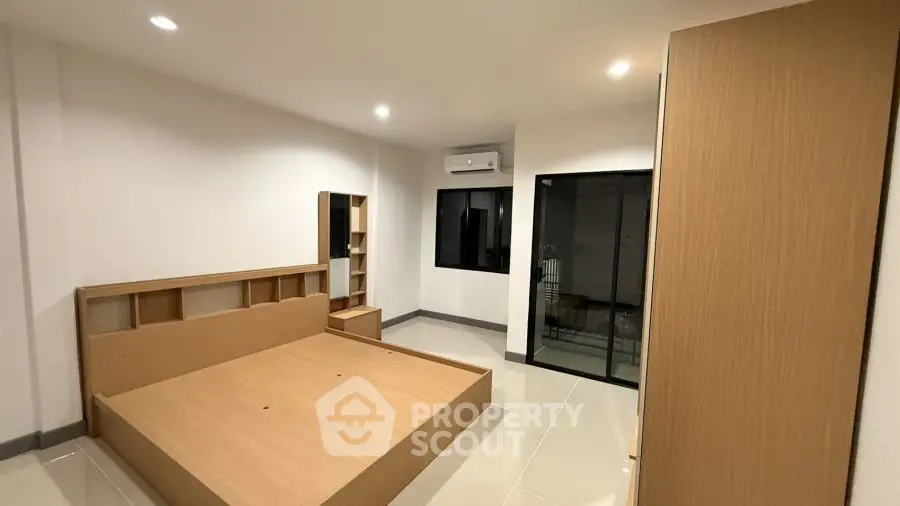 Spacious modern bedroom with minimalist design and ample natural light.