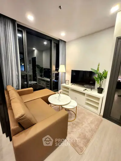 Modern living room with large windows and stylish furniture in a high-rise apartment.