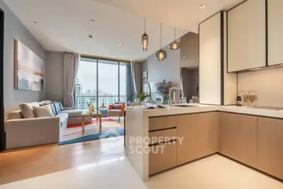 Modern open-plan living room and kitchen with city view, stylish decor, and natural light.
