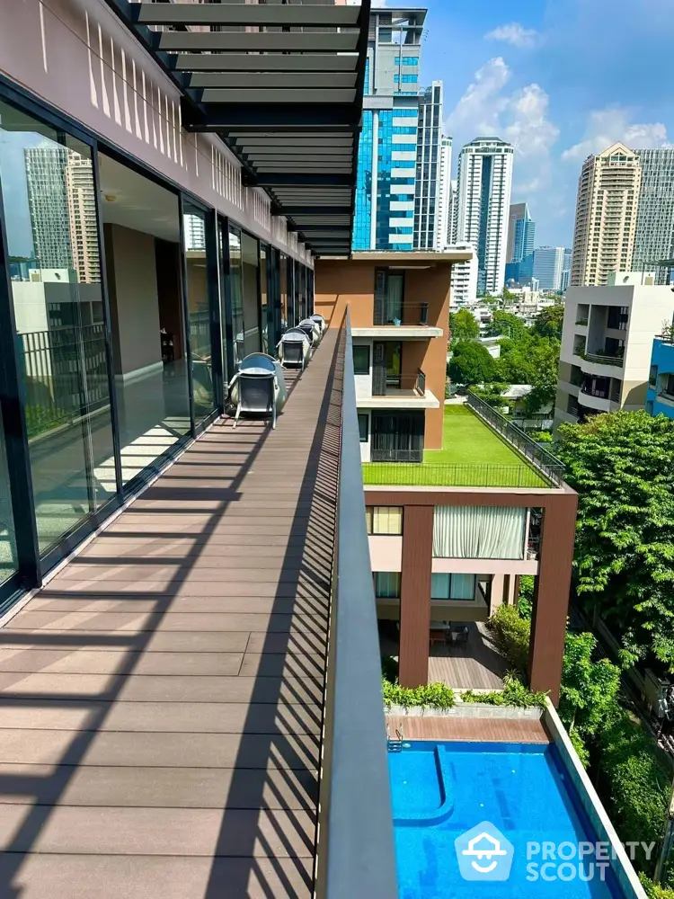 Modern urban balcony with stunning cityscape view and pool below