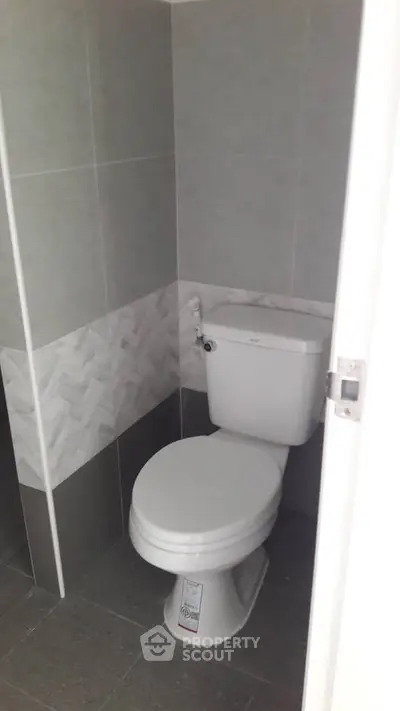 Modern bathroom with sleek gray tiles and white toilet