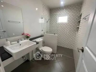 Modern bathroom with sleek design, featuring white tiles and contemporary fixtures.