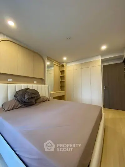 Modern bedroom with built-in wardrobe and cozy lighting, perfect for relaxation and comfort.