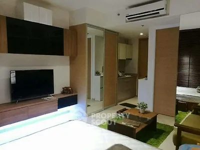 Modern living room with sleek furniture and open kitchen layout in a stylish apartment.