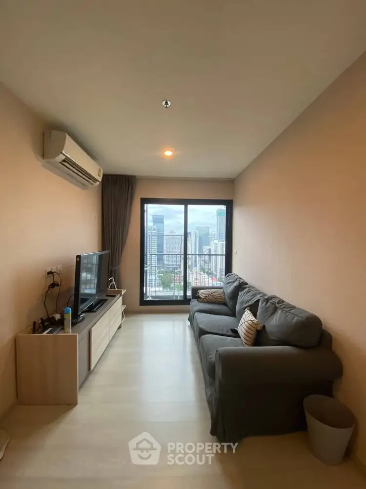 Modern living room with city view, featuring cozy sofa and entertainment setup.